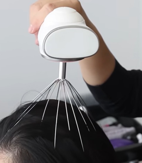 Hair wellness expert performing a relaxing scalp massage during an Indo-Korean head spa